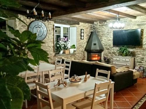蒙多涅多A Casa das Augas的客厅配有桌椅和壁炉