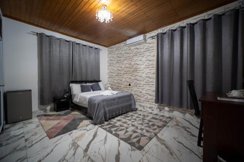 阿克拉The Cabyn的一间卧室设有一张床和砖墙