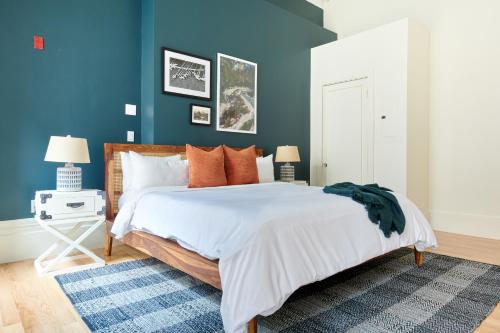 波士顿Sonder The Hancock的一间卧室拥有蓝色的墙壁,配有一张带橙色枕头的床。