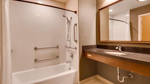 钱德勒Best Western Plus Chandler Hotel & Suites的带浴缸、水槽和镜子的浴室