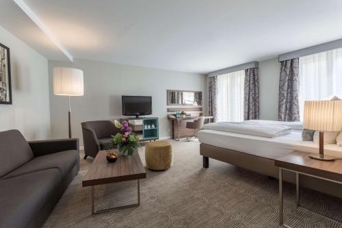 威斯巴登威斯巴登施瓦泽博克丽笙酒店的酒店客房设有一张大床和一张沙发。