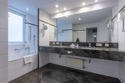 威斯巴登威斯巴登施瓦泽博克丽笙酒店的一间带水槽和大镜子的浴室