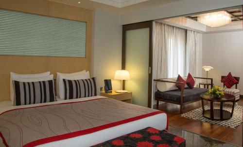 艾哈迈达巴德Radisson Blu Hotel Ahmedabad的一间卧室配有一张大床和一把椅子