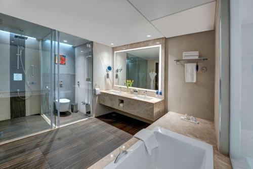 阿吉曼阿吉曼雷迪森布鲁酒店的带淋浴、盥洗盆和卫生间的浴室