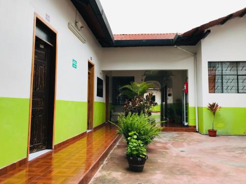 伊瓦拉Quinta San Carlos Hostel的拥有绿色和白色墙壁的庭院