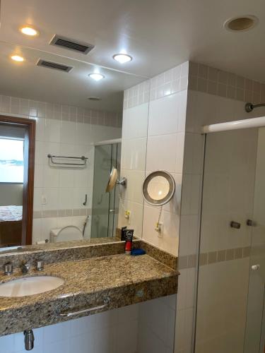 马瑙斯Flat Tropical的一间带水槽、镜子和淋浴的浴室