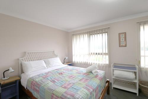 伊登阿洛韦公寓的一间卧室配有一张带彩色毯子和窗户的床。