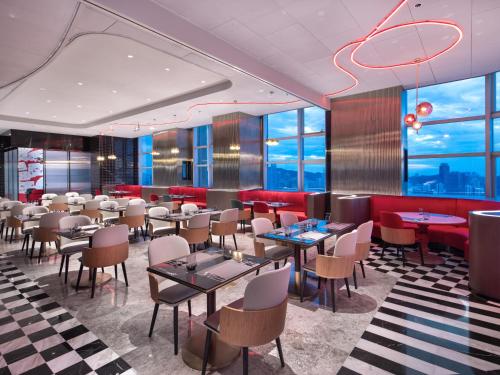 珠海珠海拱北口岸丽芮酒店的餐厅设有桌椅和窗户。