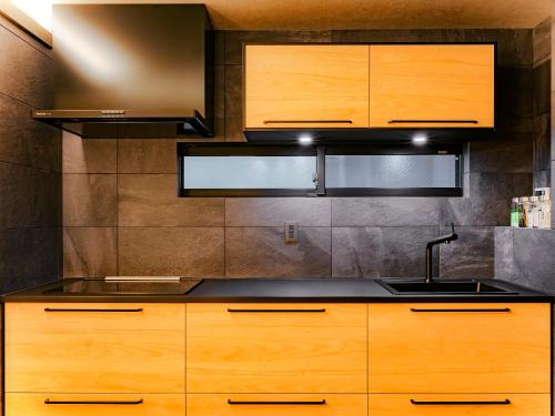 名古屋SAMURAI HOUSE Ⅲ的一个带木制橱柜和水槽的厨房