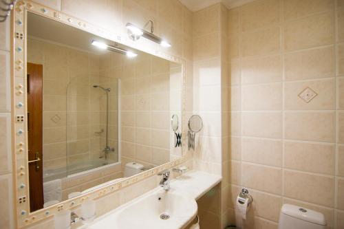 基希讷乌考米尔佛酒店的一间带水槽、镜子和卫生间的浴室