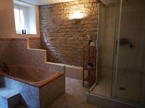 ClairvauxMaison familiale de l Abbaye的设有带浴缸和淋浴的浴室。