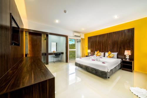 奈扬海滩Naiyang Place - Phuket Airport的一间卧室设有一张大床和黄色的墙壁