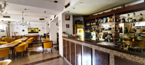 布加勒斯特5 Stars High Hostel的餐厅设有配备黄色椅子的酒吧