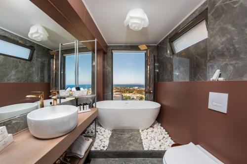 赫索尼索斯Onira Suite Dreams的一间带大浴缸和大窗户的浴室