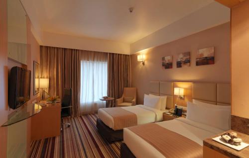 迈索尔Mysore County Retreat的酒店客房设有两张床和电视。