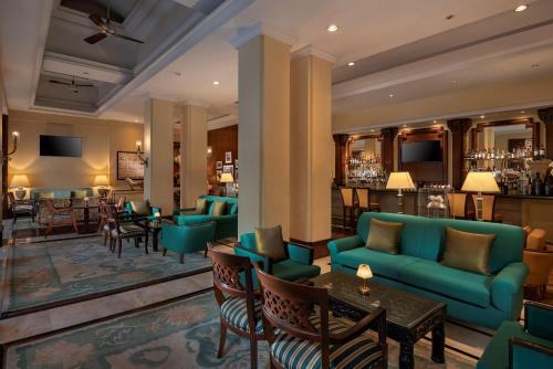 新德里德里机场丽笙世嘉酒店的酒店大堂设有蓝色的沙发和酒吧