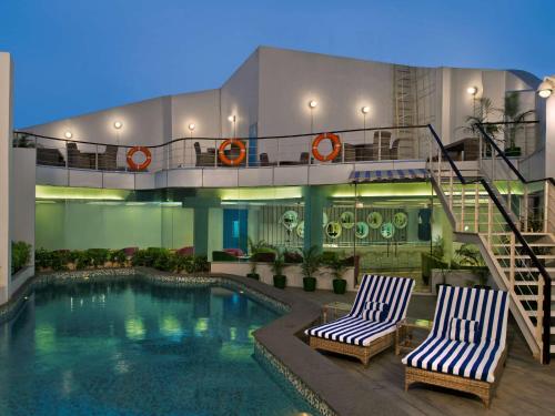 新德里新德里IP扩展区丽柏酒店的一个带两把椅子的酒店和一个游泳池