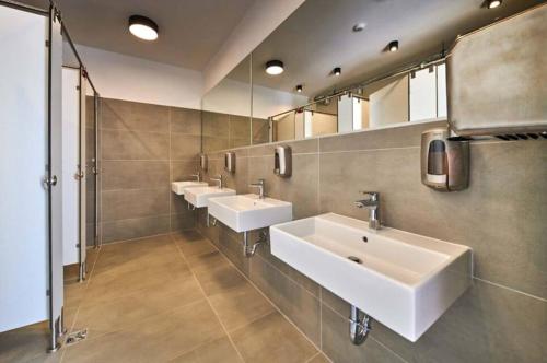 乌马格Easyatent Camping Stella Maris的浴室设有3个水槽和一排镜子