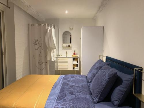 马赛Appartement atypique cosy entre terre & mer的一间卧室配有一张床,浴室设有水槽