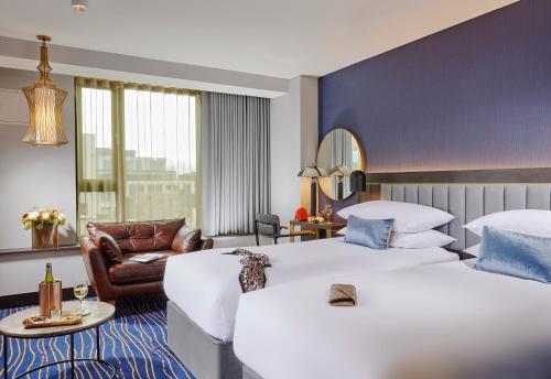 都柏林The Grafton Hotel的酒店客房,配有两张床和椅子