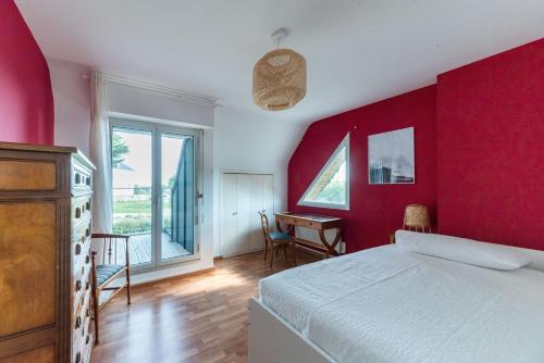 克拉斯卡诺特Les Chardonnerets - Maison contemporaine Vue Mer的一间卧室设有红色的墙壁、一张床和一张书桌