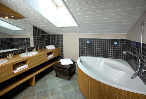 雷塞兹卡尔加里酒店的一间带大浴缸和水槽的浴室