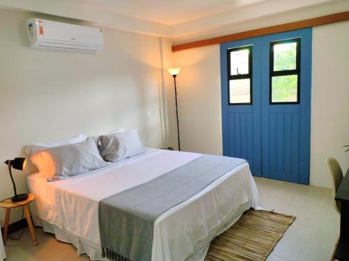 维拉维尔哈Pousada VilaZinha的一间卧室配有一张带蓝色门的床