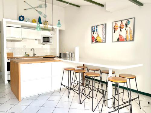 里夫杜海滩COUP DE CŒUR - ILE DE RE - Maison 3 chambres的厨房配有白色橱柜和酒吧凳子