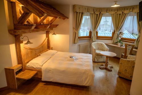博曾安古Garnì Costa Verde的一间卧室配有一张床、一把椅子和窗户。