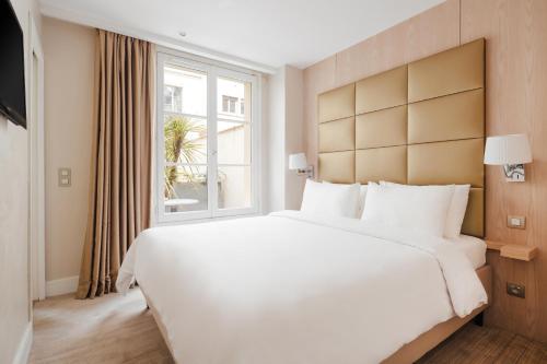 巴黎Sonder L'Edmond Parc Monceau的一张大白色床,位于酒店带窗户的房间内