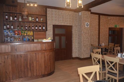 皮佐维斯Noclegi Avoca的餐厅设有酒吧、桌子和葡萄酒瓶