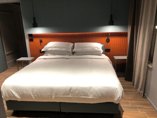 曼托瓦Materiaprima camere-rooms的卧室配有一张带白色床单和枕头的大床。