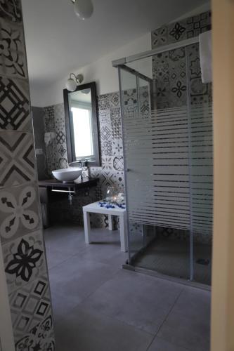 切里尼奥拉Il Borgo Suite的带淋浴、盥洗盆和镜子的浴室