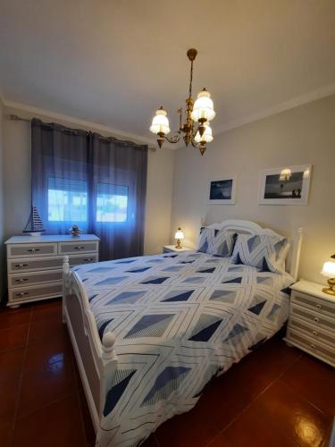 CadavalCASA DO NINHO - Entre o Campo e a Praia的卧室配有白色床和蓝色和白色棉被