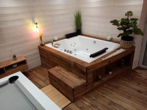 奥比埃La Vigne d'Aubière 2的带浴缸的浴室,铺有木地板