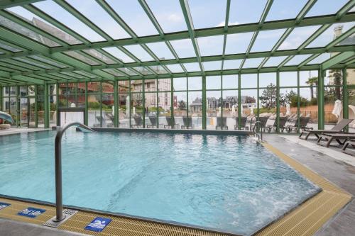 多维尔Résidence Pierre & Vacances Premium Presqu'Ile de la Touques的一个带玻璃天花板的大型游泳池