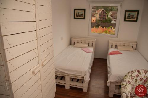 Gornja TrepčaGuesthouse Edelnice的一间设有两张床和一面墙壁的房间