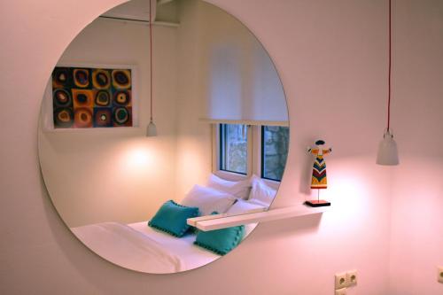 帕尔加Gallery Suites Parga的客房设有镜子和一张带窗户的床