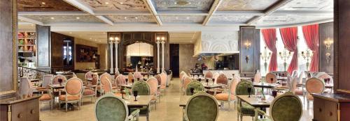 诺伊达Radisson Blu MBD Hotel Noida的一间在房间内配有桌椅的餐厅