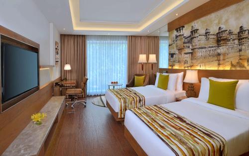 瓜廖尔Radisson Gwalior的酒店客房设有两张床和一台平面电视。
