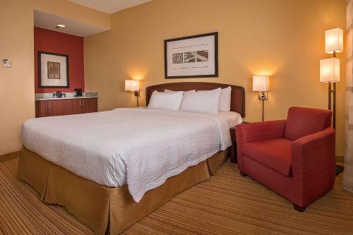 达拉姆Sonesta Select Durham Research Triangle Park的酒店客房,配有一张床和一张红色椅子