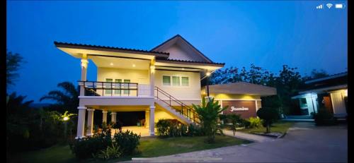王南安科帕努萨亚民宿的一间大型白色房子,晚上设有阳台