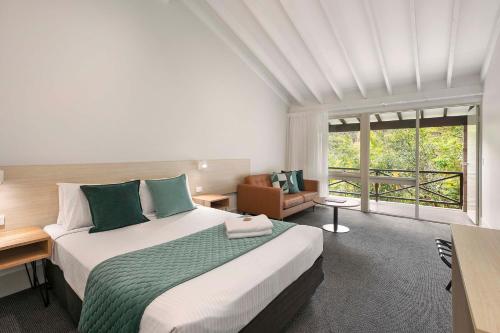 阿沃卡海滩Avoca Beach Hotel的一间卧室设有一张大床和一个大窗户