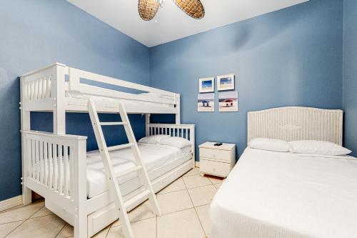 南帕诸岛Saturn Serenity & Condo的一间卧室设有两张双层床,拥有蓝色的墙壁。