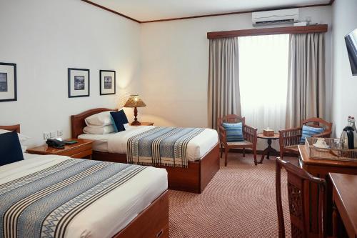 仰光赢家旅馆的酒店客房设有两张床和窗户。