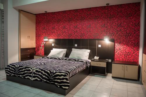 沃尼扎sozos inn hotel vonitsa的一间卧室设有一张床和红色的墙壁