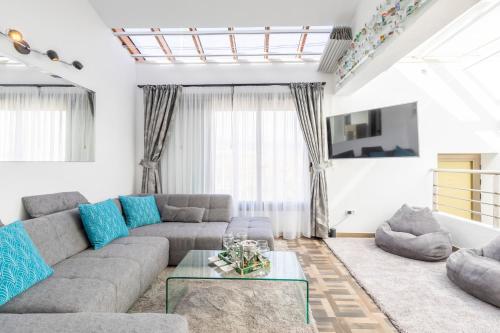 厄尔梅达诺MEDANO4YOU Barefoot Beach House的客厅配有灰色的沙发和蓝色的枕头。