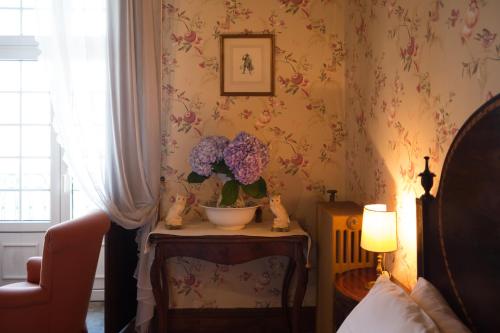 拉梅戈杜思瓦莱斯庄园旅馆的桌子上放着花瓶的房间
