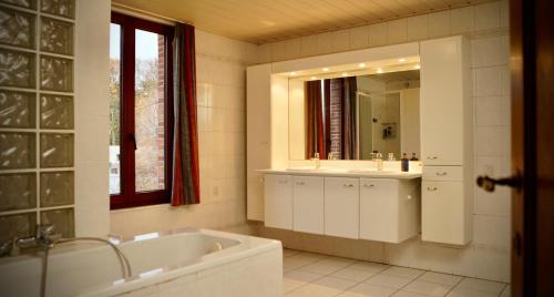 BalenDe Strikker的带浴缸、水槽和镜子的浴室