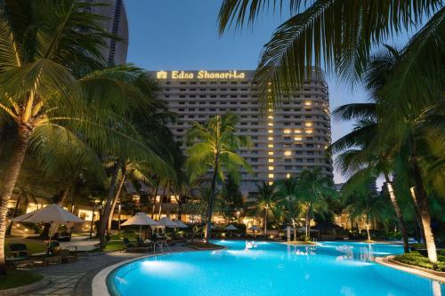 马尼拉Edsa Shangri-La, Manila的享有棕榈树酒店和游泳池的景色